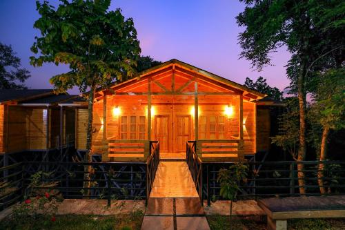 una cabina in legno con portico di notte di Woodrose Resort a Kalpetta