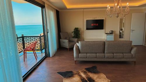 ein Wohnzimmer mit einem Sofa und Meerblick in der Unterkunft BİLİRİS HOTEL in Trabzon