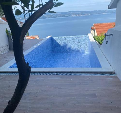 uma piscina de mergulho com vista para a água em Luxury apt w pool 3 balconies terrace & sea view em Omiš