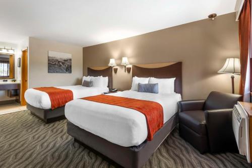 Best Western Plus Rio Grande Inn في دورانجو: غرفة فندقية بسريرين وكرسي