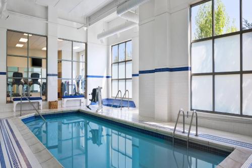 - une piscine d'eau bleue dans un bâtiment avec fenêtres dans l'établissement Sheraton St Paul Woodbury Hotel, à Woodbury