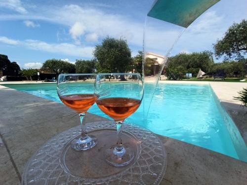 - deux verres de vin assis sur une table près de la piscine dans l'établissement Villa Marianna, à Alghero