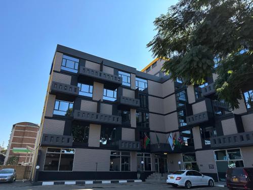 哈拉雷N1 Hotel Samora Machel Harare的前面有汽车停放的建筑