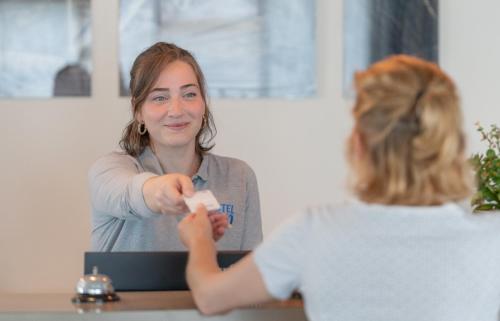 een vrouw aan een tafel die een videospel speelt bij Hotel Inn Design La Rochelle in La Rochelle