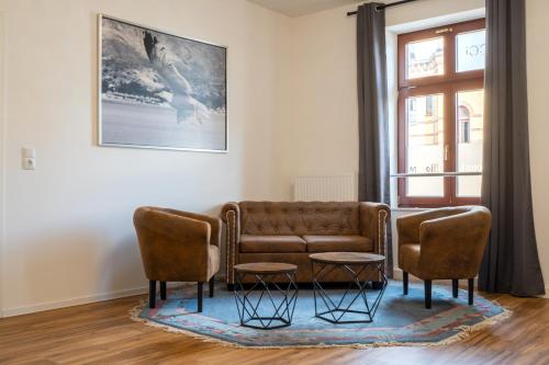 a living room with a couch and two chairs at Gwuni Mopera in Leipzig