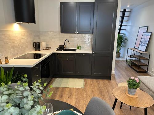 a kitchen with black cabinets and a living room at Abrahama Green House in Władysławowo