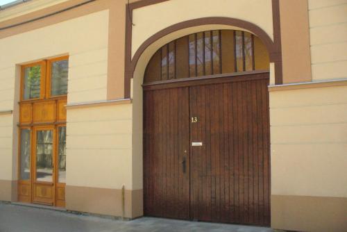 una gran puerta de madera en el lateral de un edificio en Berta Apartman, en Senta