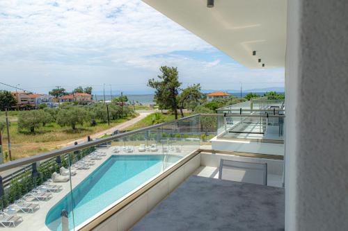 uma varanda com vista para uma piscina em The Angeliki Boutique Hotel em Skala Rachoniou