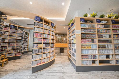 een bibliotheek met rijen boeken op de planken bij QuintessaHotel TokyoHaneda Comic&Books in Tokyo