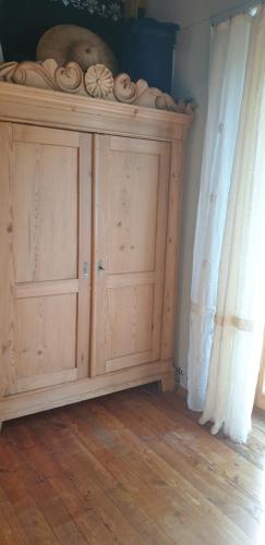 un armario de madera en una habitación junto a una ventana en Mājīga istaba ar balkonu un vannasistaba, bezmaksas velo noma, en Iecava