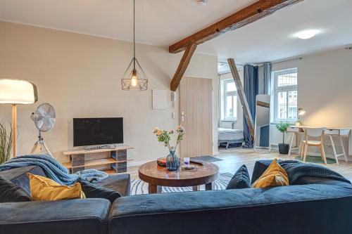 ein Wohnzimmer mit einem blauen Sofa und einem Tisch in der Unterkunft Residenz unter den Linden Specht in Mühlhausen