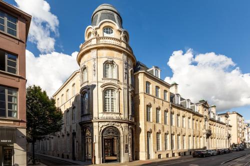 a large building with a clock tower on a street at Sapphire House Antwerp, Autograph Collection in Antwerp