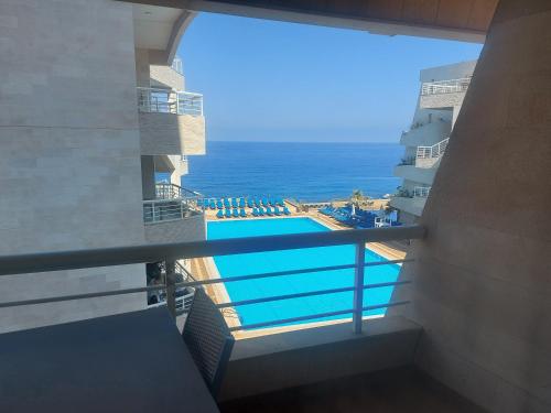 - une vue sur la piscine depuis le balcon de l'hôtel dans l'établissement Castel Mare Beach Hotel & Resort, à Byblos