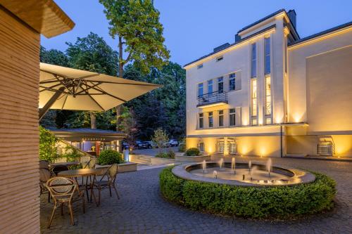 un edificio con ombrellone e tavoli e sedie di Lion's Castle Hotel a Lviv