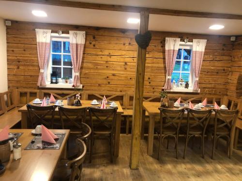 un ristorante con pareti e tavoli in legno e finestre di Pension Soutěsky a Hřensko