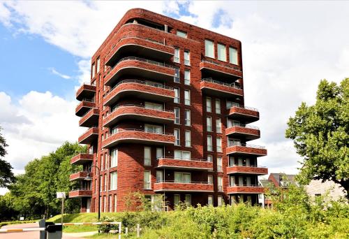 ein hohes rotes Backsteingebäude mit vielen Fenstern in der Unterkunft Dormio Hotel De Prins van Oranje in Maastricht