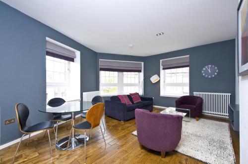 un soggiorno con pareti blu e tavolo e sedie di Destiny Scotland -The Malt House Apartments a Edimburgo