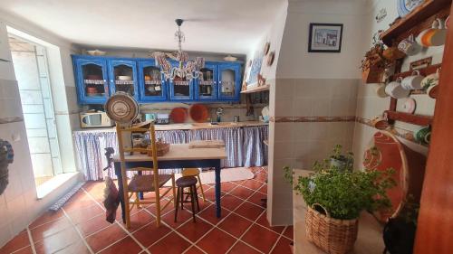 a kitchen with blue cabinets and a table and chairs at Casa da Muralha in Estremoz