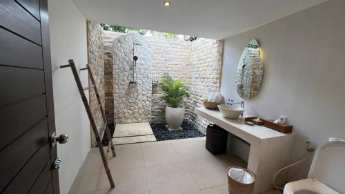 a bathroom with a stone shower and a sink at Living Asia Resort and Spa in Senggigi 