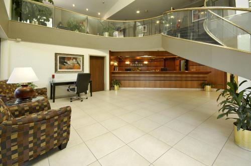 eine Lobby mit einer Treppe und einem Wartezimmer in der Unterkunft Ramada by Wyndham Bettendorf in Bettendorf