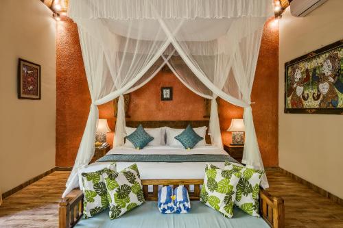 1 dormitorio con 1 cama con dosel en Teja Lokha Ubud Villa, en Ubud