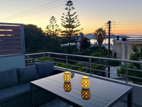 un tavolo su un balcone con due luci di Aria sea view, Chania a Stalós