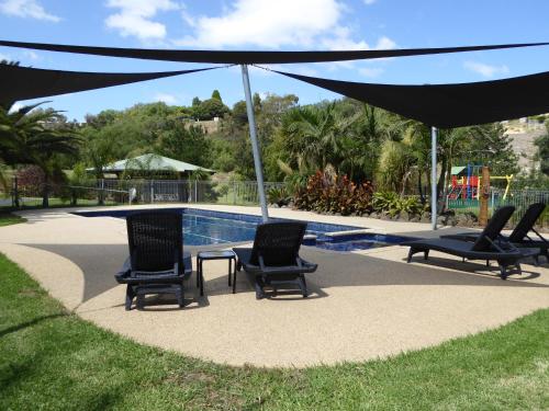 un gruppo di sedie sotto un ombrellone accanto alla piscina di Barwon Valley Lodge a Geelong