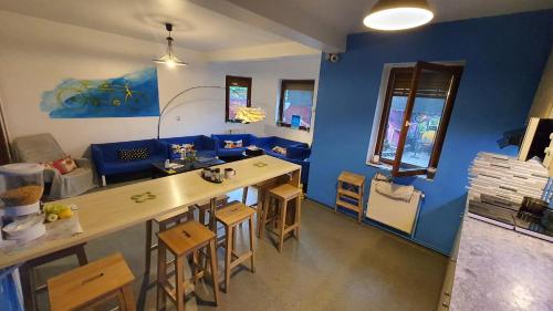 ein Wohnzimmer mit einem Tisch und einer blauen Wand in der Unterkunft Popcorn Hostel in Bukarest