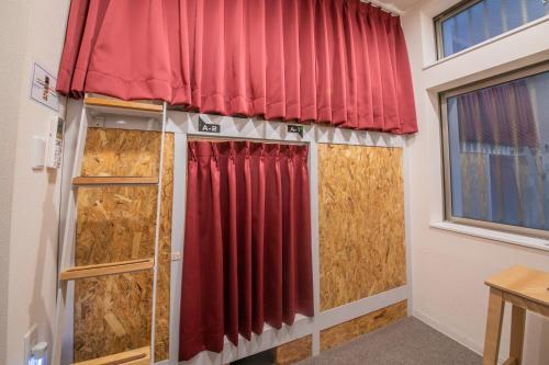 a room with a red curtain and a window at KIZUNA HOTEL Gojo Kiyomizu-dera Kamogawa in Kyoto