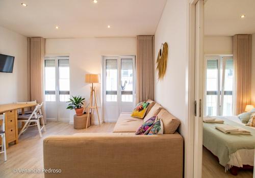 sala de estar con sofá y escritorio en Nesha Ericeira Flats, en Ericeira