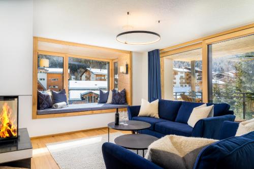 sala de estar con sofá azul y chimenea en Riverside 2nd Floor South, en Saas-Fee