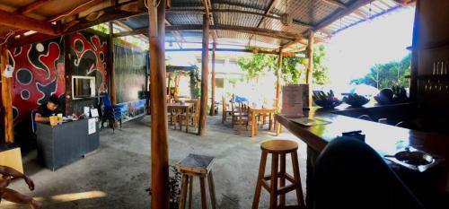 a restaurant with a bar and tables and chairs at Achita Cottages in Senaru