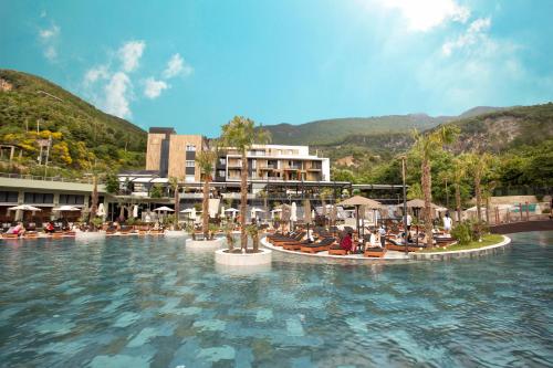 una piscina del resort con sedie e ombrelloni in acqua di Select Hill Resort a Tirana