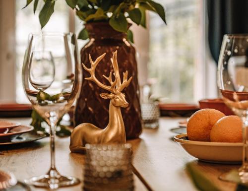 a table with glasses and a figurine of a deer on it at Willa Skalniak in Lądek-Zdrój