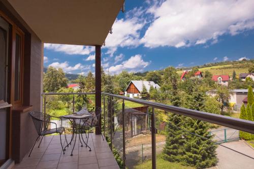 balcone con tavolo, sedie e vista di PRESTIGE PARK apartament z tarasem i parkingiem a Krynica-Zdrój