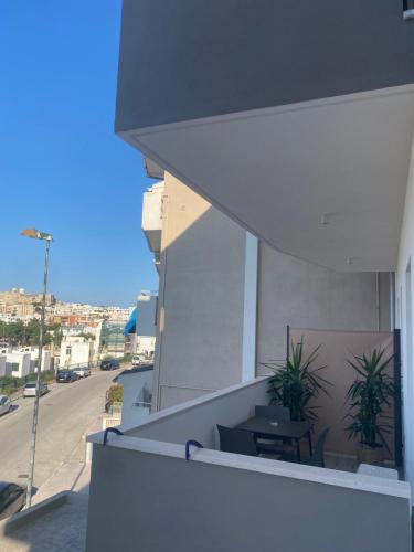 un balcone con tavolo e piante su un edificio di VIESTEROOMS a Vieste