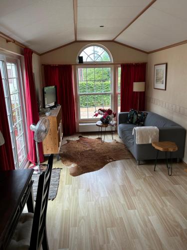 a living room with a couch and a window at Slapen op De Bult Green 2 persons in De Bult