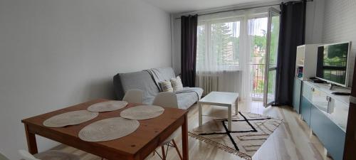 uma sala de estar com uma mesa e um sofá em CITY VIEW Zamenhofa II em Świdnica