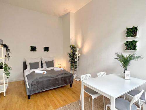 Schlafzimmer mit einem Bett, einem Tisch und Stühlen in der Unterkunft Jungle Retreat Apartments im Zentrum in Bremen