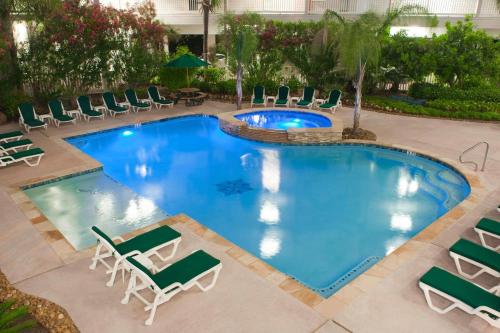 eine Aussicht über den Pool mit Chaiselongues und einem Resort in der Unterkunft Beachfront View Condo at Casa Del Mar in Galveston