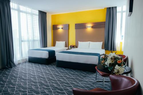 A bed or beds in a room at Hotel Sentral Kuantan @ Riverview City Centre