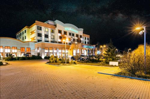 un hôtel la nuit avec un parking devant lui dans l'établissement Hotel Savannah, à Chvalovice