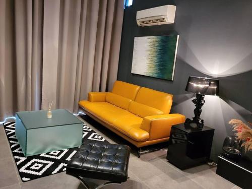 sala de estar con sofá amarillo y mesa en Empire Damansara Designer Soho Karaoke & Netflix, en Petaling Jaya