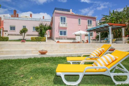 un grupo de sillones sentados en el césped en Villa House Joana Vasconcelos, Ocean view & Pool - Pata da Gaivota, en Lourinhã