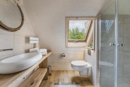 a bathroom with a sink and a toilet and a shower at Willa Skała in Kościelisko