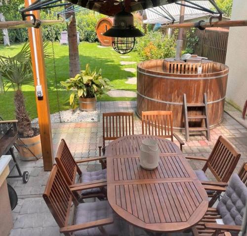 een patio met een tafel en stoelen en een vat bij Abigél Vendégház Keszthely in Keszthely