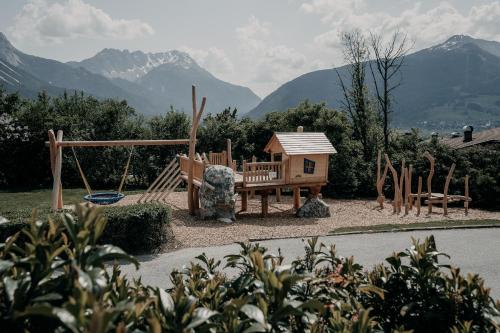 um parque infantil com uma casa e um baloiço em Alpenappartements Cristall em Ehrwald