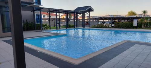 Miri Sunsky Condominium Homestay 3 Rooms & 6 Guest في ميري: مسبح ازرق كبير في مبنى