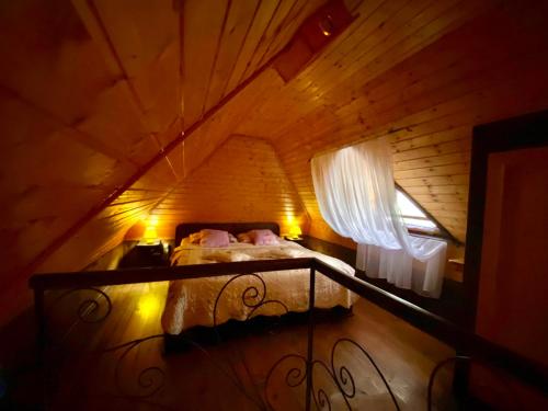 a bed in a wooden room with a window at Brvnare Platan - oaza prirode in Vrdnik