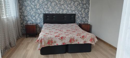 a bedroom with a bed with a floral bedspread on it at Resort In Gonio in Kvariati